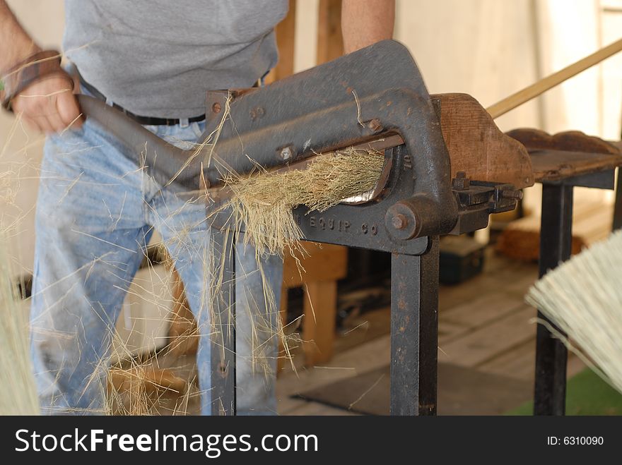 A worker creates an old fashioned broom. A worker creates an old fashioned broom.