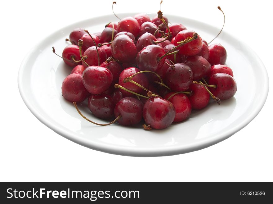Plate of sweet cherries isolated on white. Plate of sweet cherries isolated on white