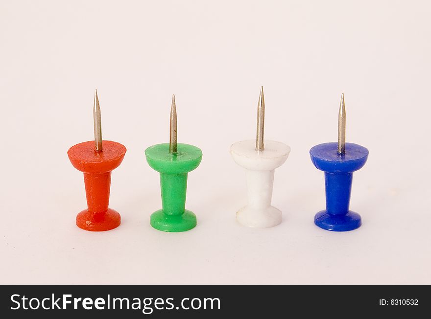 Four coloured push-pins standing on a white background. Four coloured push-pins standing on a white background