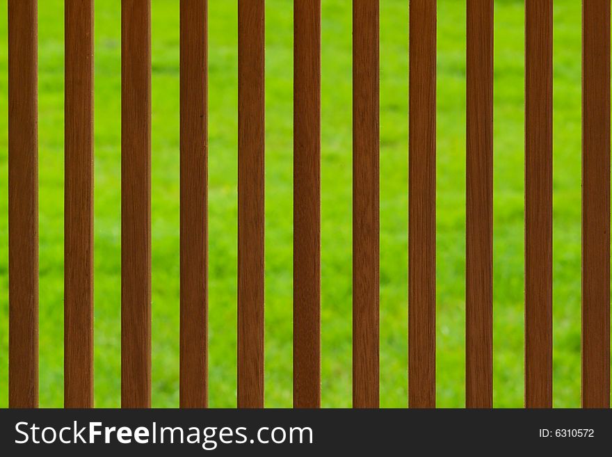 Brown wooden fence background over green lawn