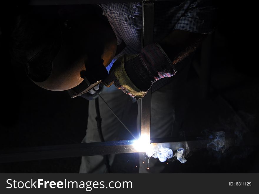 A welder makes a door by merging donate several pieces of metal. A welder makes a door by merging donate several pieces of metal.