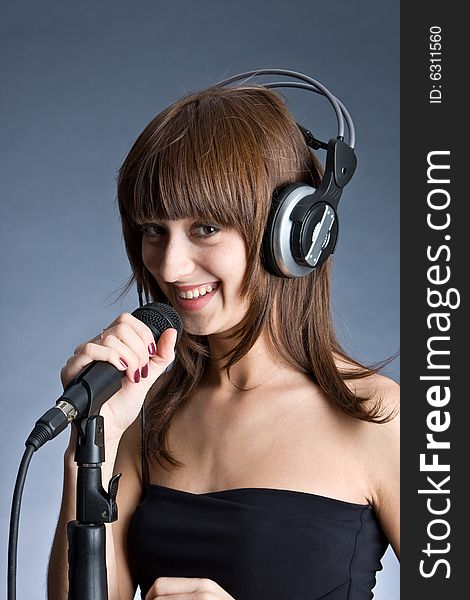 Woman in headphones Singing into Microphone