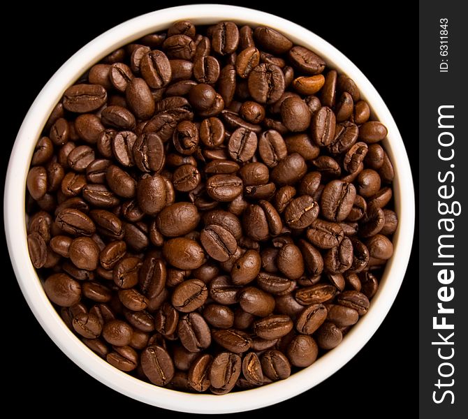 Coffee beans in a white bowl isolated on black background