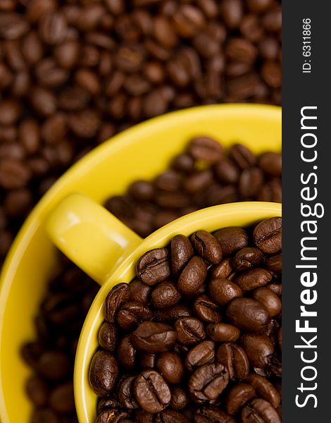 Coffee beans in a yellow cup on a background with nice DoF