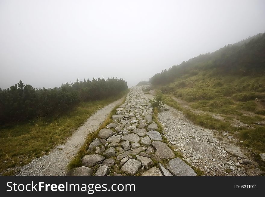 Misty pathway in Polish Tatras on an overcast day