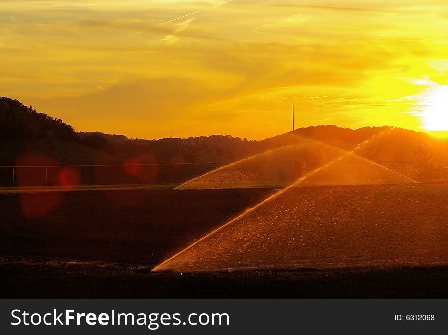 Time to water the field as the sun sets