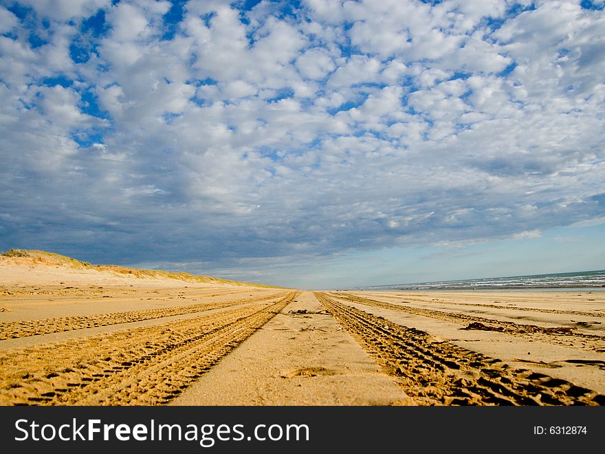 4WD Tracks going over the horizon on the beach. 4WD Tracks going over the horizon on the beach