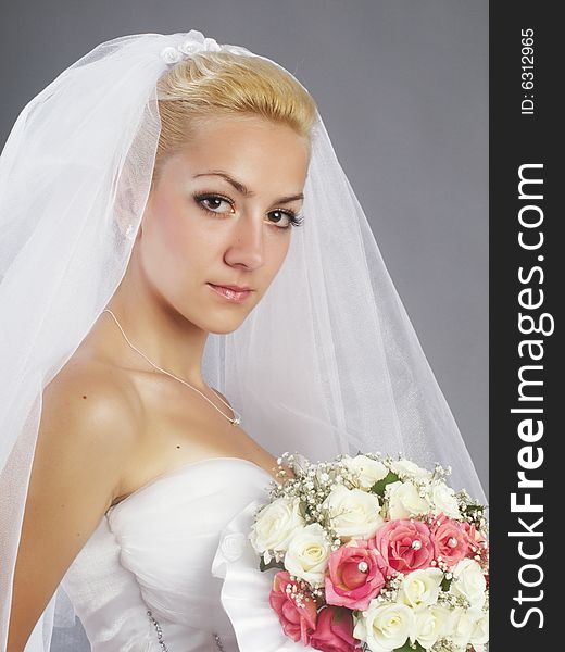 Portrait of beautiful bride on grey background studio shot