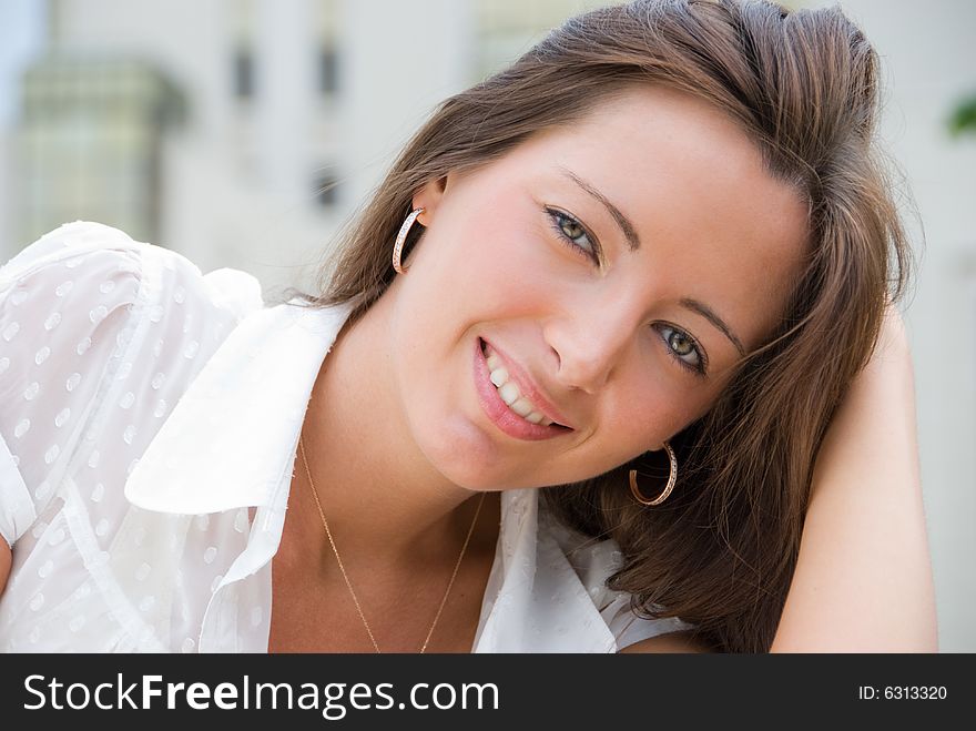 Portrait of a young cute woman sitting outdoors. Portrait of a young cute woman sitting outdoors