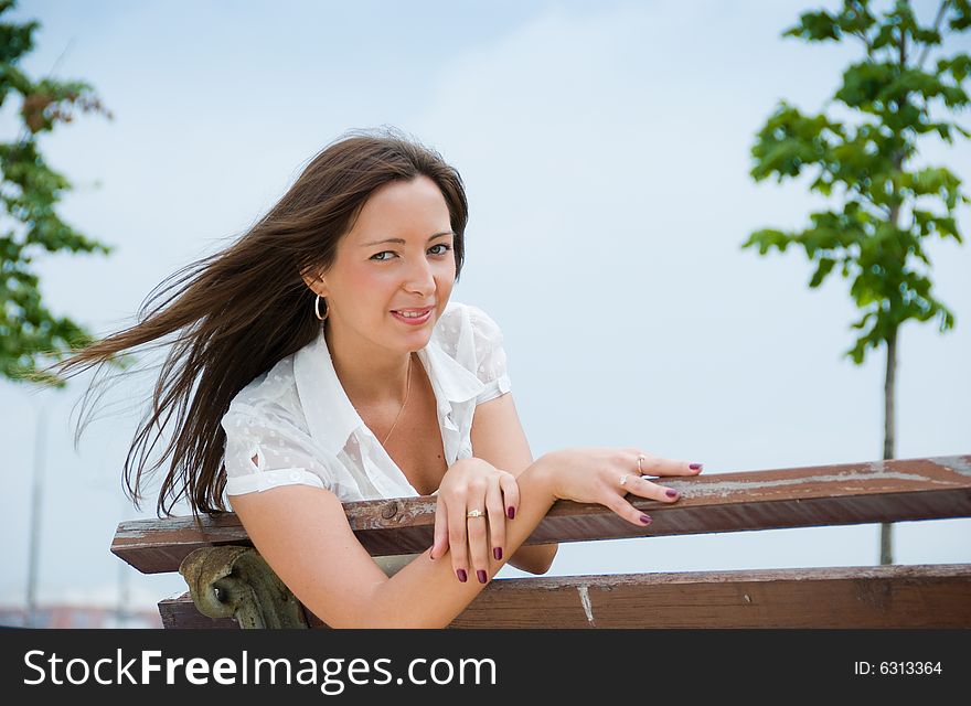 Portrait of a young cute woman sitting outdoors. Portrait of a young cute woman sitting outdoors