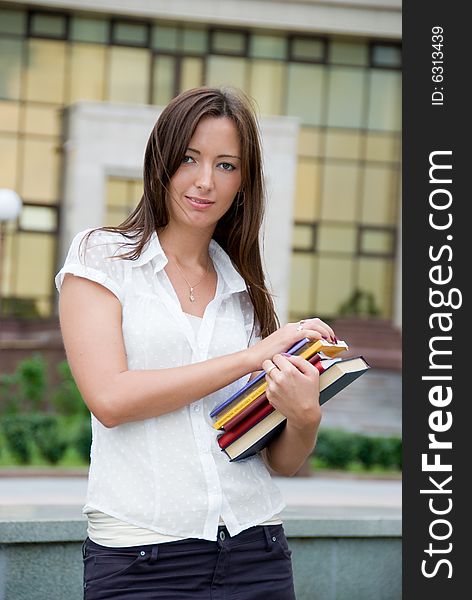 Cute student holds books in her hands.