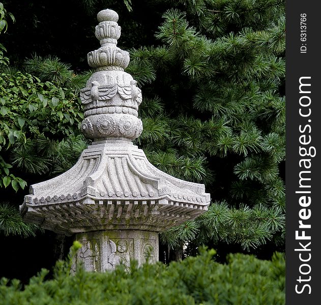 The top of a monument at a Korean temple peeks out from a grove of trees. The top of a monument at a Korean temple peeks out from a grove of trees.