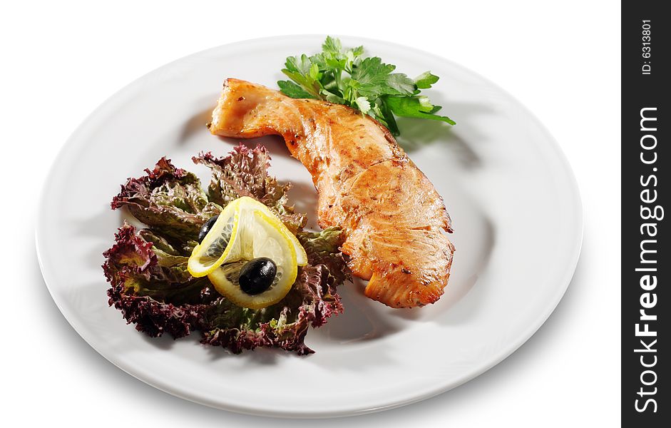 Steak from Filleted Fish (Salmon) with Lemon Slice Olive and Salad on a Plate. Isolated on White Background. Steak from Filleted Fish (Salmon) with Lemon Slice Olive and Salad on a Plate. Isolated on White Background