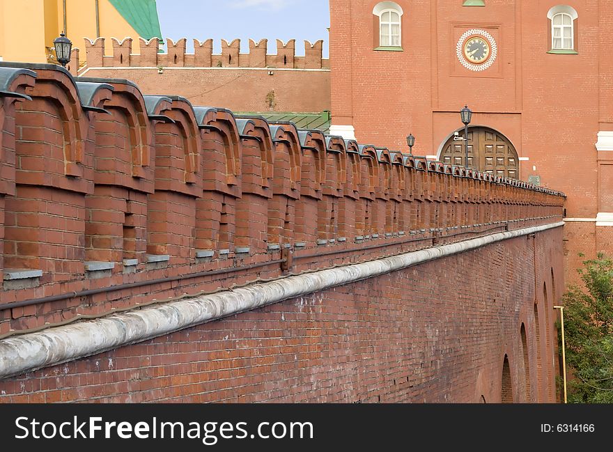 Kremlin wall in front of the gates in the Kremlin. The little clock on the tower.