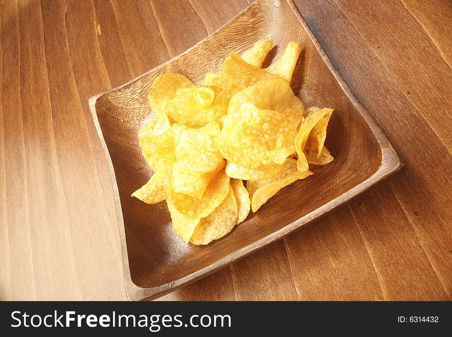 Crunchy potato chip in a wooden bowl. Crunchy potato chip in a wooden bowl