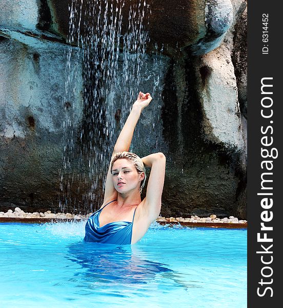 Woman wearing an evening dress in the pool during a trash the dress session.