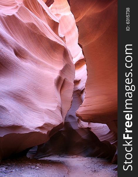 Hiking trail within the slot canyon showing the scale and monumental rock formations hanging over the trail. Hiking trail within the slot canyon showing the scale and monumental rock formations hanging over the trail