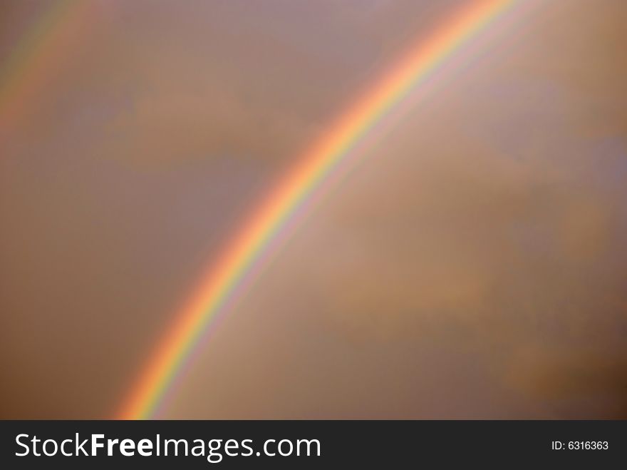 Colorful bright rainbow set against stormy sky. Colorful bright rainbow set against stormy sky