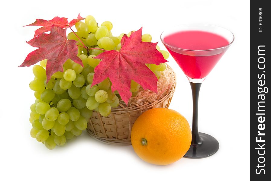 Red maple leaves and ripe fruit in a basket on a white background