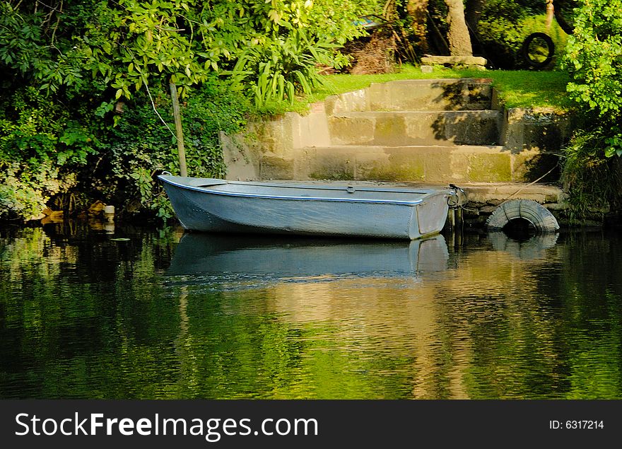Boat in the river near the embankment in summer day. Boat in the river near the embankment in summer day
