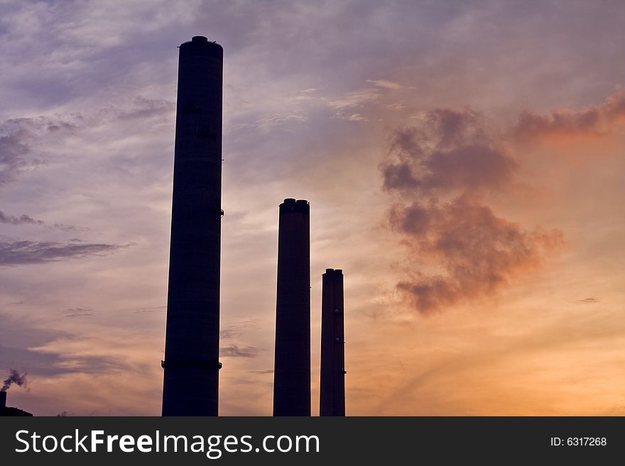 Power station chimneys at sunset with smoke. Power station chimneys at sunset with smoke