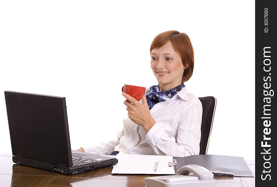 Young beautiful businesswoman with a red cup behind a desktop. Portrait in a high key. Young beautiful businesswoman with a red cup behind a desktop. Portrait in a high key.