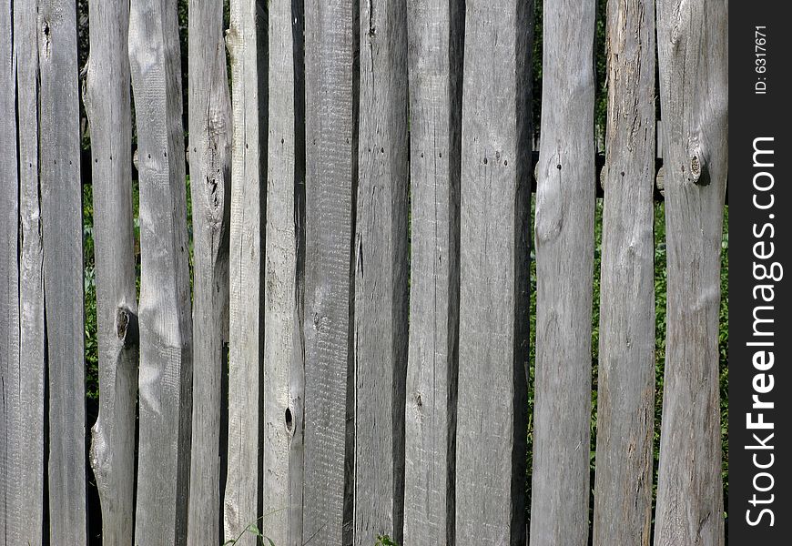 Fragment of old uncolored wooden slab fence. Fragment of old uncolored wooden slab fence