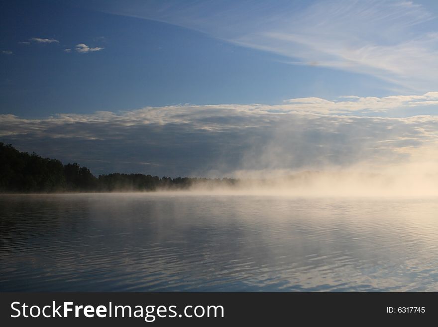 Foggy summer morning on lake