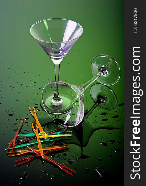 Two cocktail glasses on green background