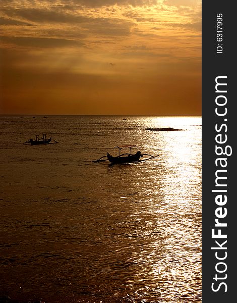 Two outrigger canoes on the sea at sunset. Two outrigger canoes on the sea at sunset.