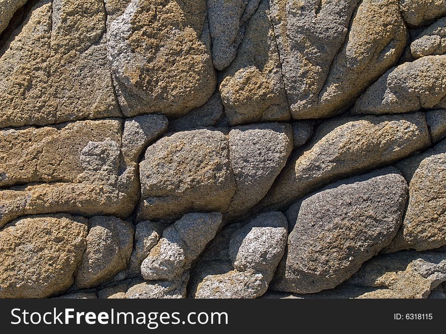 A close-up of the texture of very rough surface of rock on seacoast. Russian Far East, Japanese sea, Primorye. A close-up of the texture of very rough surface of rock on seacoast. Russian Far East, Japanese sea, Primorye.