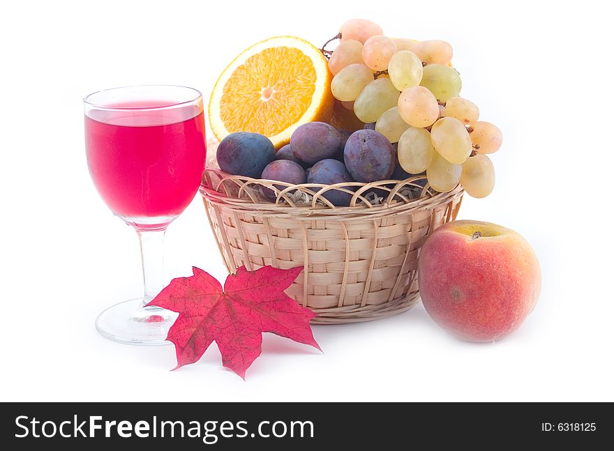 Grapes in a yellow basket and wine with maple leaves on a white background