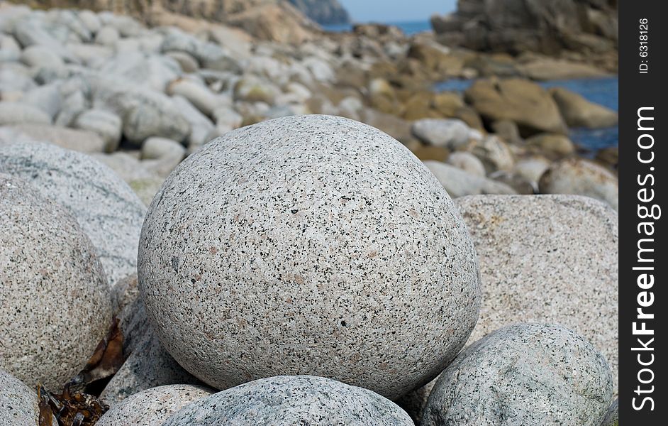 A close-up of stone granite ball on seacoast. A close-up of stone granite ball on seacoast.