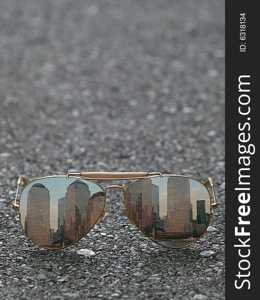 Sunglasses with the reflection of skylines on asphalt