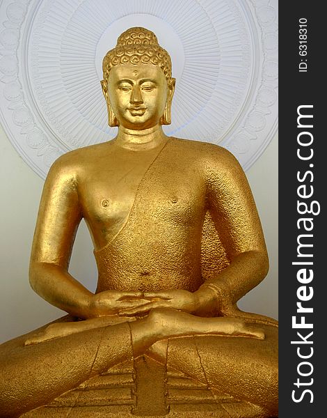 A Buddhist statue in gold on a white background. A Buddhist statue in gold on a white background.