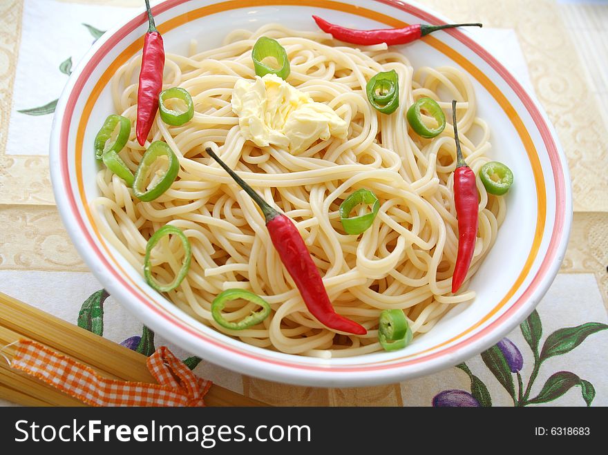 A bowl with spaghetti, chillis and spring onions. A bowl with spaghetti, chillis and spring onions