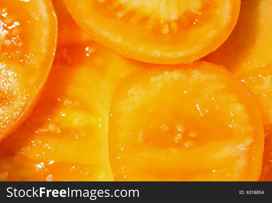 Close up of the yellow sliced tomatoes. Background.