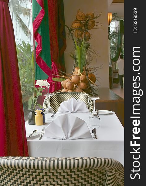 Restaurant table near by window decored with coconut. Restaurant table near by window decored with coconut