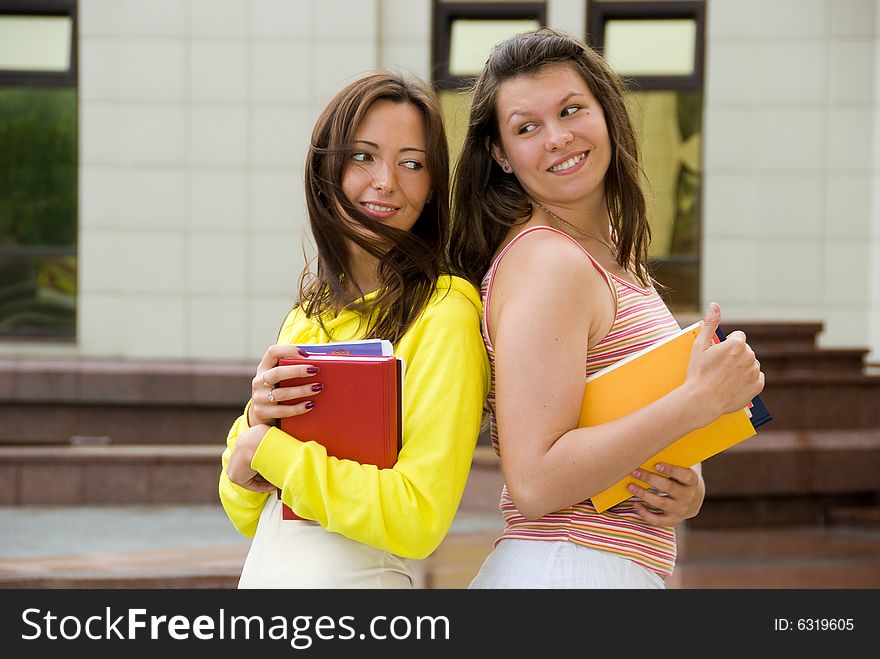 Two cute students hold books in their hands