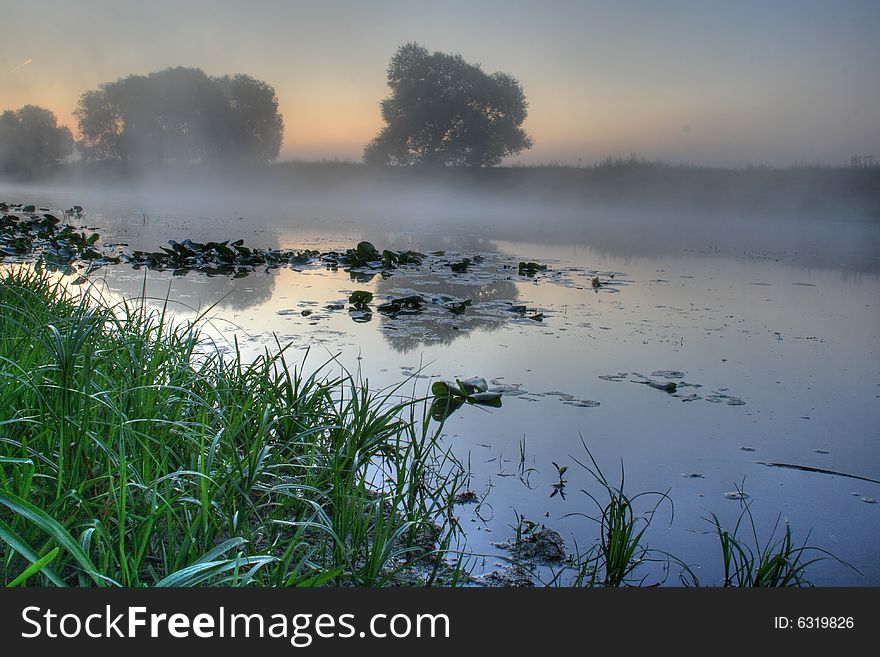 Beautiful foggy river with reflection