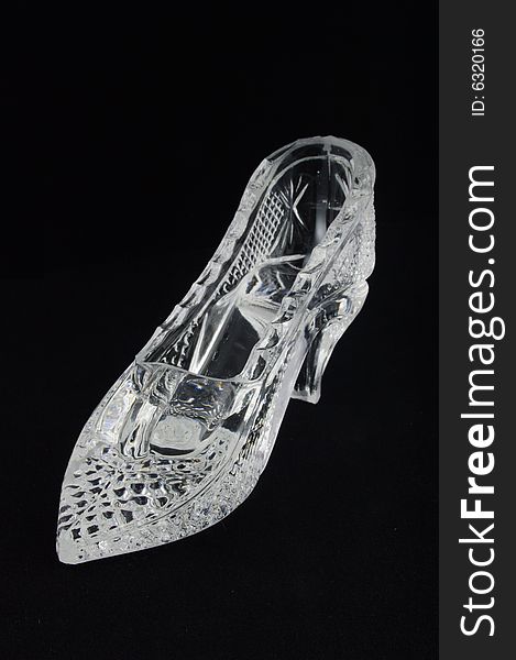 Crystal glass slipper over black background