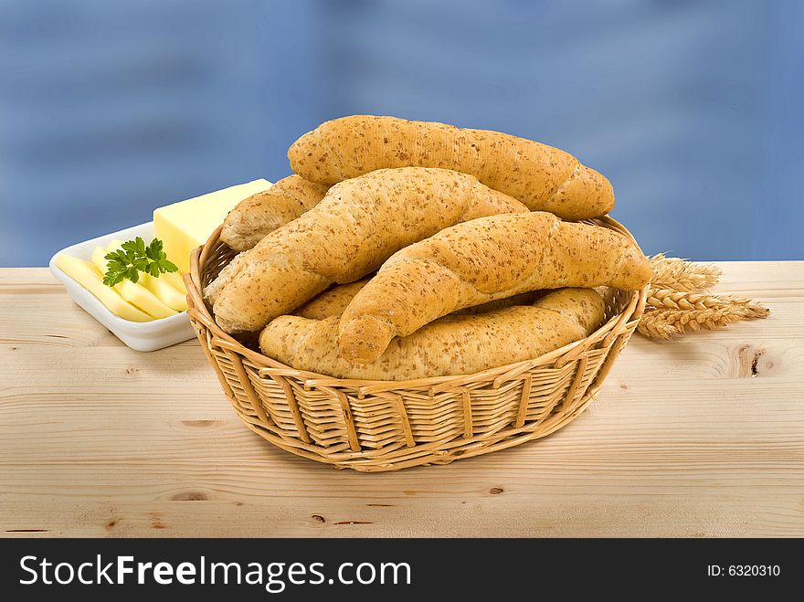 Still life of wholegrain rolls in a basket and buttter