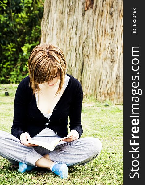 Young woman portrait reading in the park. Young woman portrait reading in the park.