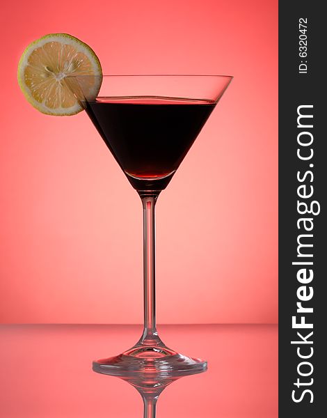 Cocktail with lemon slice on re background