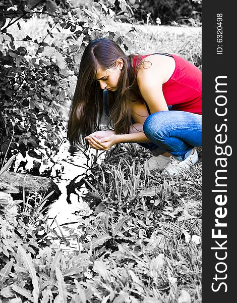 Young woman in color contrasting with dead nature surrounding her.