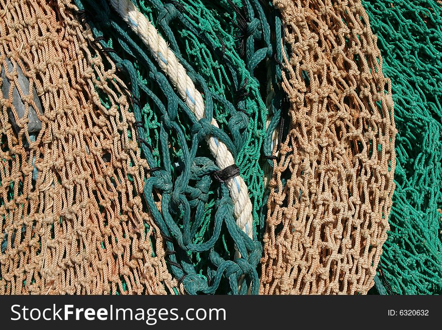 Yellow and green fishing nets drying in sun