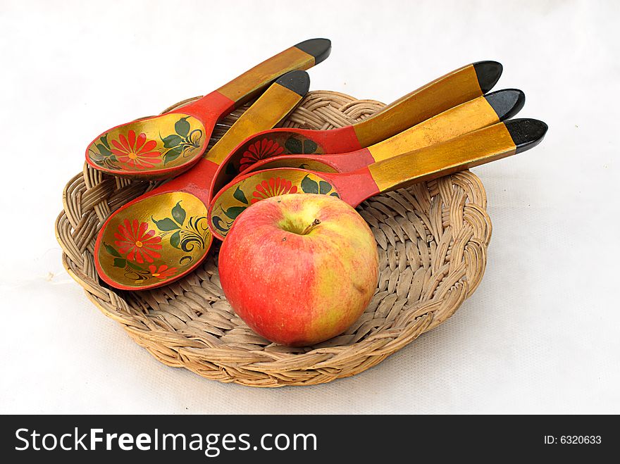 Wooden plate, spoons and red apple. Wooden plate, spoons and red apple