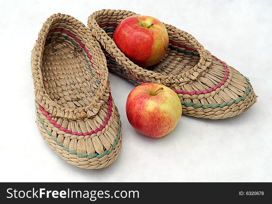 Bast shoes and two apples