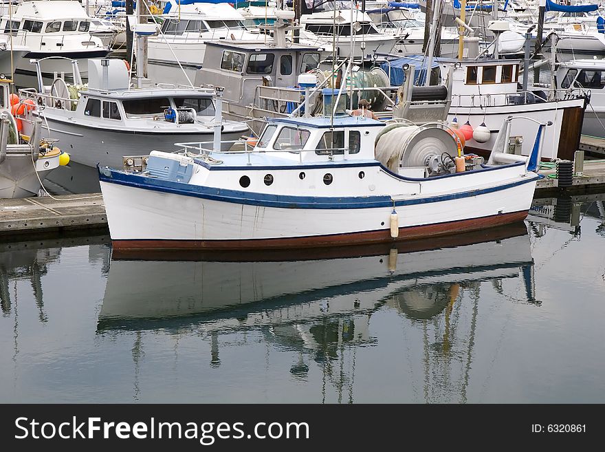 A blue and white fishing boat in a harbor. A blue and white fishing boat in a harbor