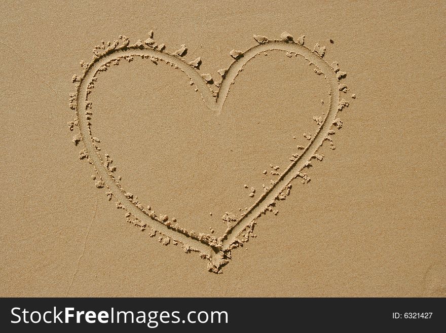 Heart drawn into sand as background